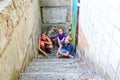 Children in the basement, three boys and a girl near the iron door are hiding on the steps from the outside world. Post-production Royalty Free Stock Photo