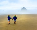 Children on Beach. Backs to Camera. Cannon Beach. Royalty Free Stock Photo