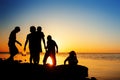 Children on the beach, fishing. Sunset shot, rear view. Sea background. Royalty Free Stock Photo