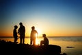Children on the beach, fishing. Sunset shot, rear view. Sea background. Royalty Free Stock Photo