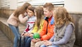 Children on a bench playing Chinese whispers