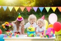 Children blow candles on birthday cake. Kids party