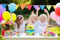 Children blow candles on birthday cake. Kids party