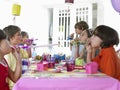 Children Blowing Party Puffers At Table