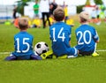 Children In Blue Sportswear Sitting On Soccer Pitch And Watching Game