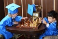 Children in blue suits play chess Royalty Free Stock Photo