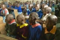 Children in blue uniforms at school behind desk near Tsavo National Park, Kenya, Africa