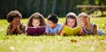 Children, books and lying in park with friends, learning or diversity for reading at school playground. Kids, education Royalty Free Stock Photo