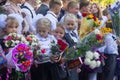 Children with bouquets of flowers enrolled in the first grade with high school students at school the solemn ruler in day of knowl Royalty Free Stock Photo