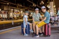 Children, boy brothers holding suitcases, travelin, waiting at trainstation to go to the airport Royalty Free Stock Photo