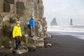 Children, boy brothers, posing on the rock of black sand beach of Reynisfjara and the mount Reynisfjall in Iceland on a cold Royalty Free Stock Photo