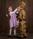 Children boy are dressed as soldier in retro military uniforms and girl in pink dress Royalty Free Stock Photo