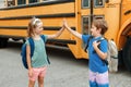 Children boy and girl kids students give hands high five by yellow school bus. Education and back to school in September. Friends Royalty Free Stock Photo