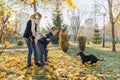 Children boy and girl playing with dachshund dog in a sunny autumn park Royalty Free Stock Photo