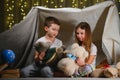 Children boy and girl playing and frighten each other with flashlight in tent at night Royalty Free Stock Photo