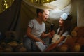 children boy and girl playing and frighten each other with flashlight in tent at night. Royalty Free Stock Photo