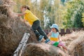 Children boy and girl on summer vacation frolic jumping on the village hayloft.