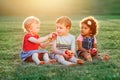 Children boy and girls sitting together sharing and eating apple food