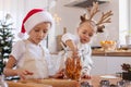 Children a boy and a little girl in the kitchen decorated for Christmas take orange chips from a jar Royalty Free Stock Photo