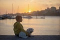 Children, boys, brothers, enjoying sunset over river with their pet maltese dog and mom, boats, sun, river