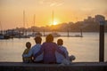 Children, boys, brothers, enjoying sunset over river with their pet maltese dog and mom, boats, sun, river