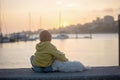 Children, boys, brothers, enjoying sunset over river with their pet maltese dog and mom, boats, sun, river Royalty Free Stock Photo