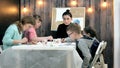 Children boys and girls sitting together around the table in classroom and drawing. With them is their young and Royalty Free Stock Photo