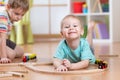 Children boys playing rail road toy in nursery