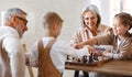 Children brother and sister playing chess while sitting in living room with senior grandparents Royalty Free Stock Photo