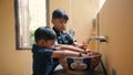 Children brothers are washing hands in the bathroom. Indonesian or malasian siblings washing hands together
