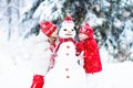 Kids building snowman. Children in snow. Winter fun.