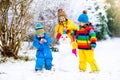 Kids building snowman. Children in snow. Winter fun.