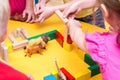 Children build a zoo of wooden bricks on table Royalty Free Stock Photo