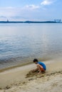 Children building sand castle beside the beach near Sembawang Park, Singapore.