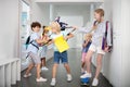 Children bullying poor boy while taking his backpack and pushing Royalty Free Stock Photo