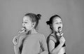 Children with busy faces pose with candies on green background