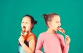 Children with busy faces pose with candies on green background