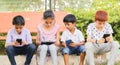 Children busy in using mobile phone at park - Concept of Kids on mobile devices and technology addiction - Young teens