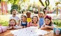 Children with cake standing around table on birthday party in garden in summer. Royalty Free Stock Photo