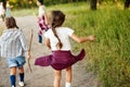 Children in casual clothes, holding hands, walking in meadow on warm sunny day. Exploring nature Royalty Free Stock Photo