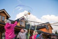 Children catching giant soap bubbles