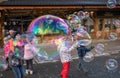 Children catching giant soap bubbles