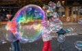 Children catching giant soap bubbles