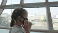 Children caucasian at airport with wearing protective medical mask on head against the background of plane. Coronavirus