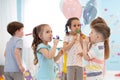 Children celebrating birthday party with noisemakers