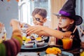 Children celebrating Halloween at kindergarten eating thematic sweets