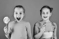 Children with cheerful faces pose with candies on green