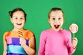 Children with cheerful faces pose with candies on green