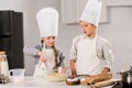 children in chef hats and aprons whisking eggs in bowl at table Royalty Free Stock Photo