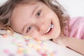 Children and chocolate. Joyful girl with sweets.A cheerful girl plays and eats chocolate multi-colored round candies on a light Royalty Free Stock Photo